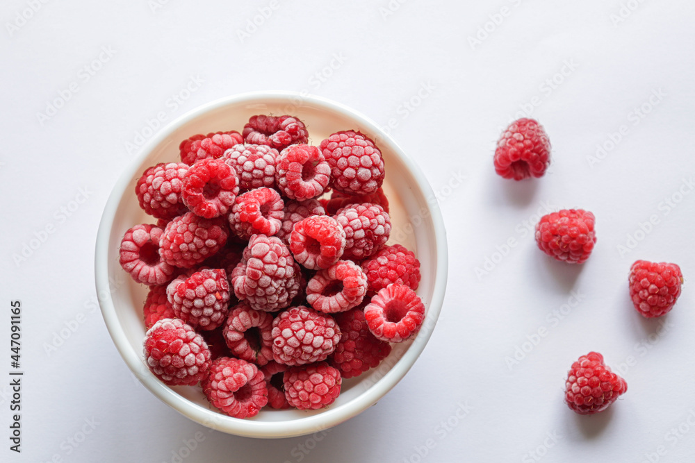 Frozen raspberries in a bowl. Fresh red raspberries isolation on white Frozen raspberries in a bowl. Fresh red raspberries isolation on white