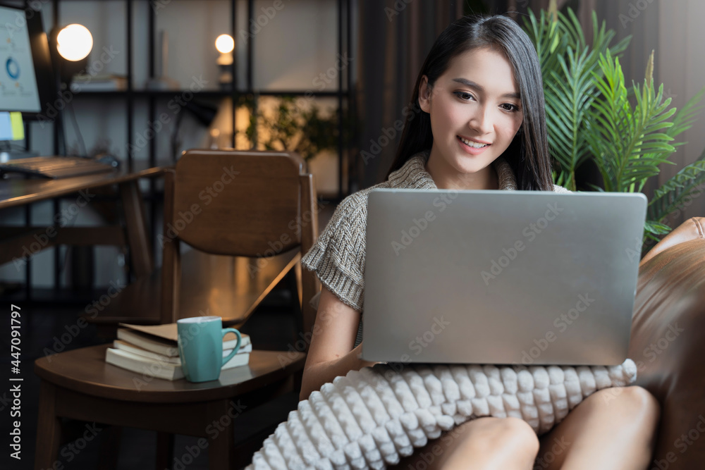 young attrative asian female working at home hand use laptop checking businesss planning report with leisure relax on sofa in living room home isolate concept young attrative asian female working at home hand use laptop checking businesss planning report with leisure relax on sofa in living room home isolate concept