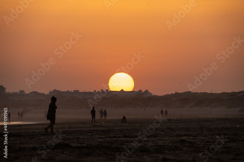 sunset on the beach of huelva with silhouettes of people