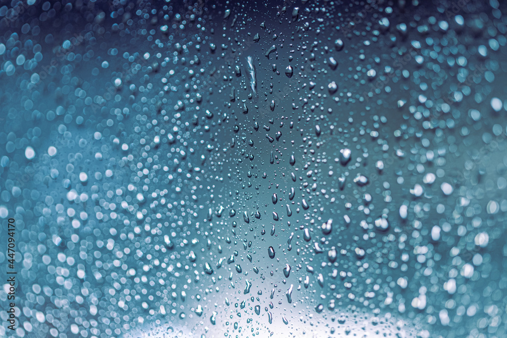 Fototapeta premium Rain drops on the window, rainy night with cool lights. Drop pattern.