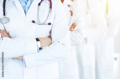 Group of modern doctors standing as a team with arms crossed in sunny hospital. Medical help, insurance in health care, best desease treatment and medicine concept