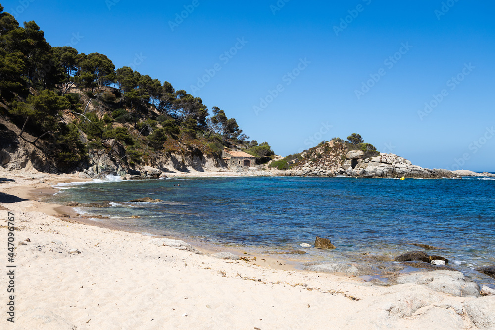 Cala estreta in Palamos, Costa Brava, Spain, sandy beach with sea and rocky mountain