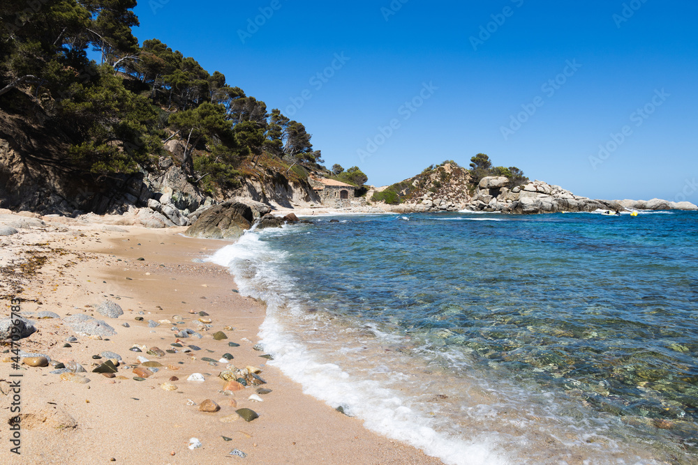 Cala estreta in Palamos, Costa Brava, Spain, sandy beach with sea and rocky mountain