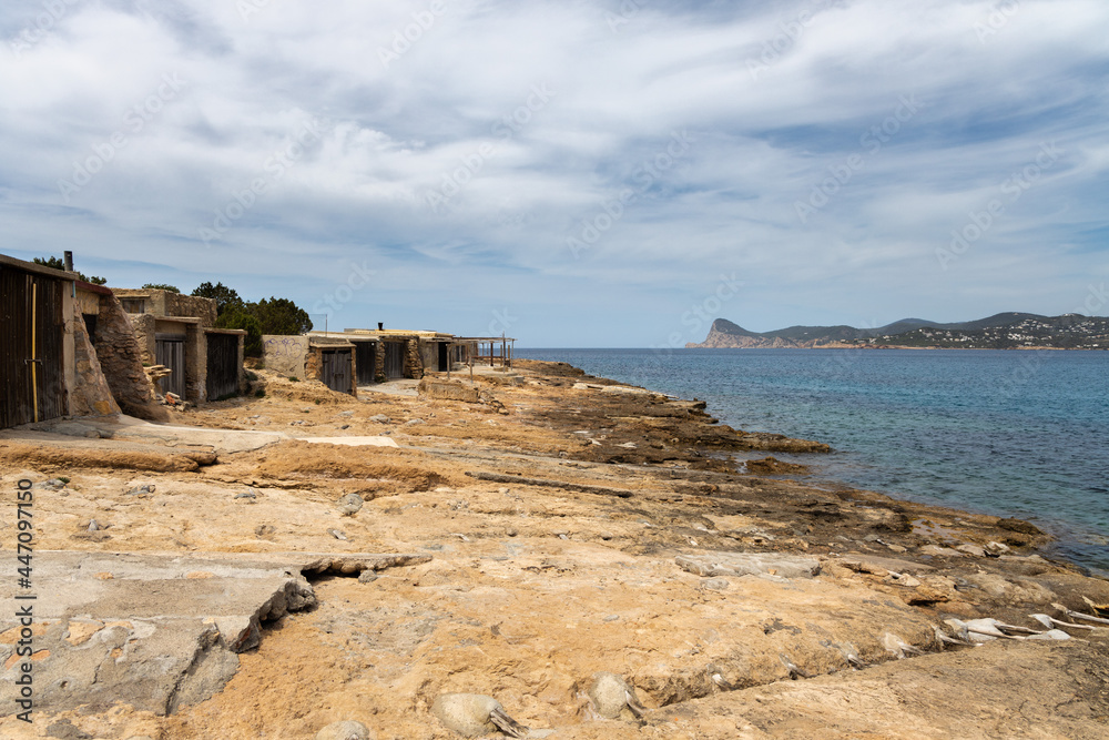 Boathouses on the rocky yellow beach in Ibiza, Spain Boathouses on the rocky yellow beach in Ibiza, Spain
