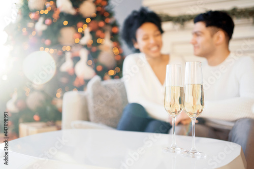 A young happy couple are preparing for Christmas. Celebrate the holiday with champagne in glasses. New Year's weekend on the eve.