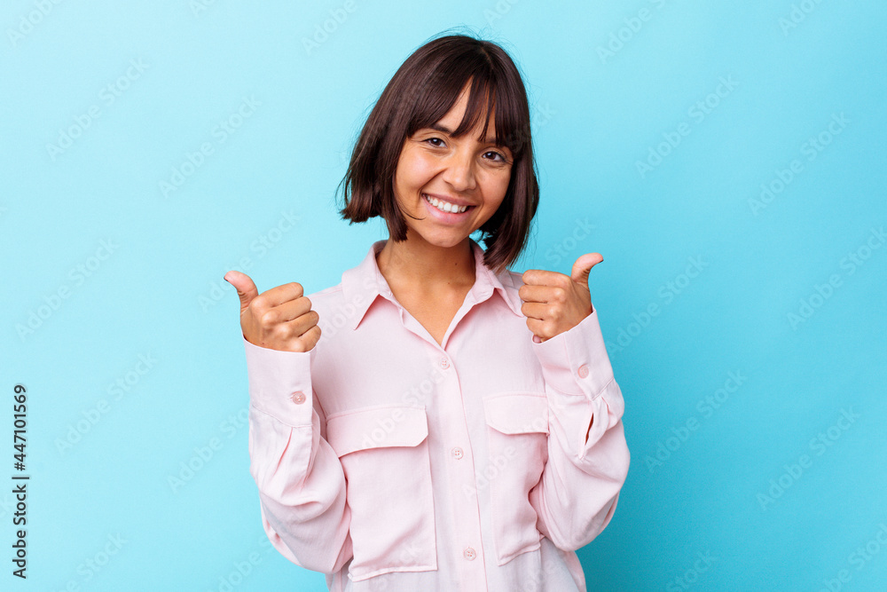 Young mixed race woman isolated on blue background raising both thumbs up, smiling and confident. Young mixed race woman isolated on blue background raising both thumbs up, smiling and confident.