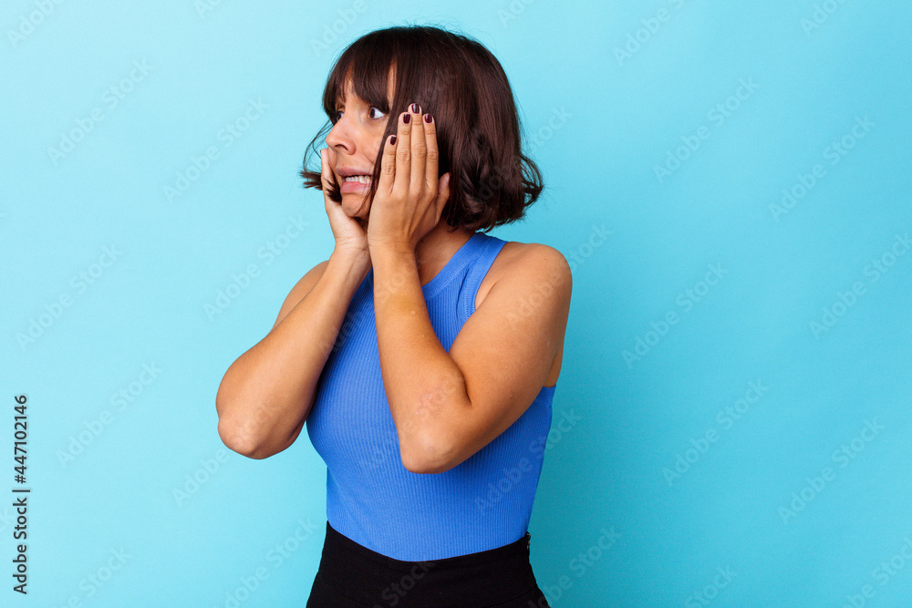 Young mixed race woman isolated on blue background scared and afraid. Young mixed race woman isolated on blue background scared and afraid.