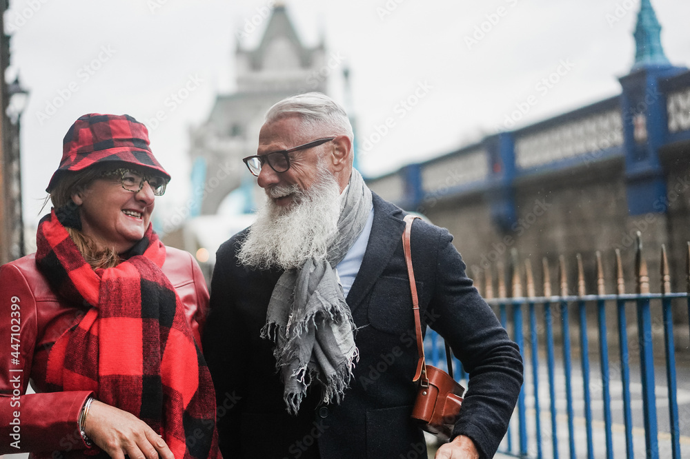 Happy senior couple having fun walking outdoors by the London city - Focus on man face