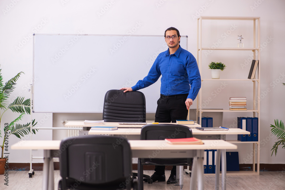 Young male teacher in front of whiteboard Young male teacher in front of whiteboard