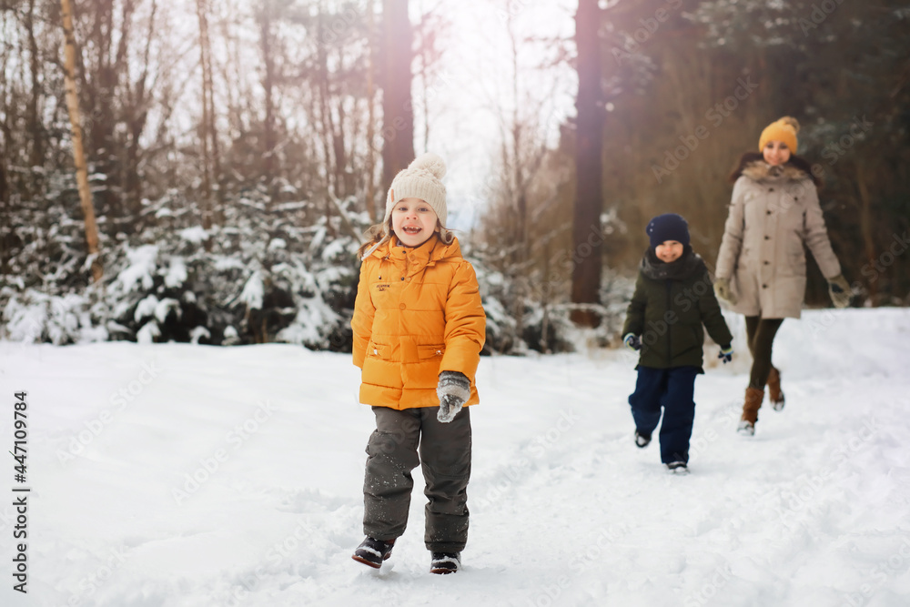 Happy family playing and laughing in winter outdoors in the snow. City park winter day.