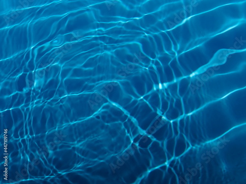 Swimming pool water surface with sparkling light reflections