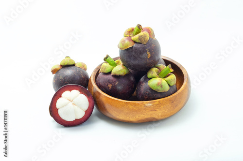 Mangosteen and cross section showing the thick purple skin and white on white background. Queen of fruits.