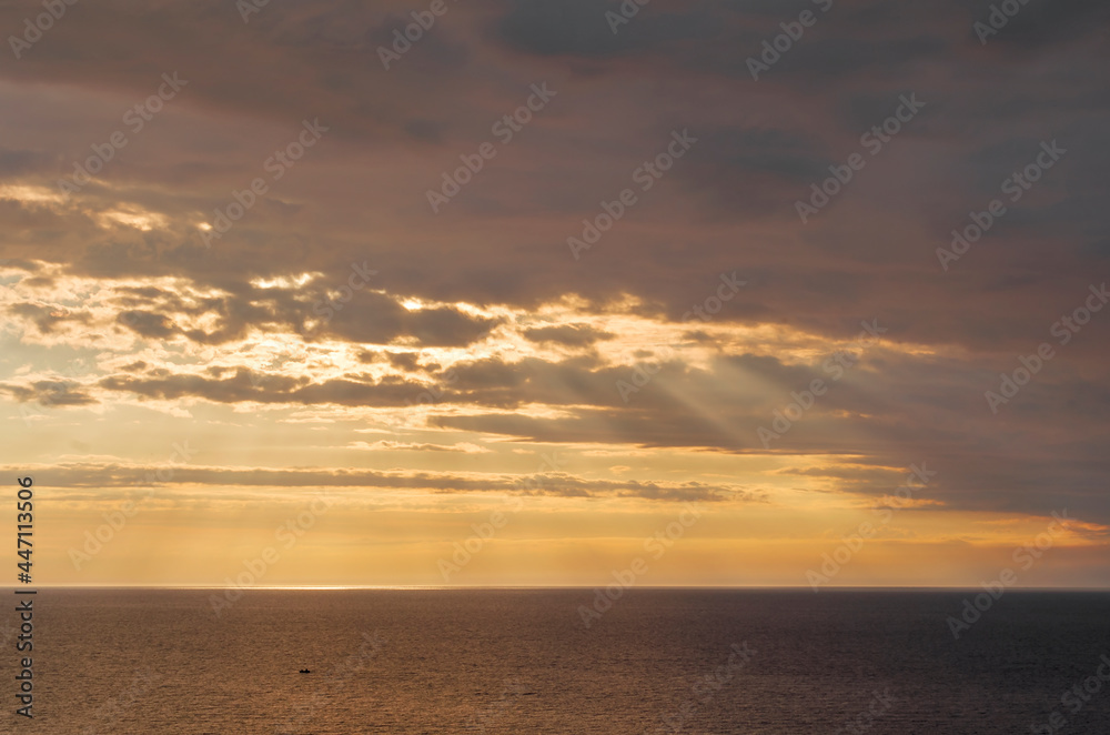 Beautiful summer sunset over the baltic sea. The sun rays pass through the clouds