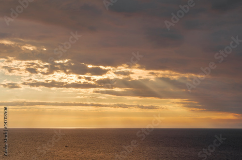 Beautiful summer sunset over the baltic sea. The sun rays pass through the clouds