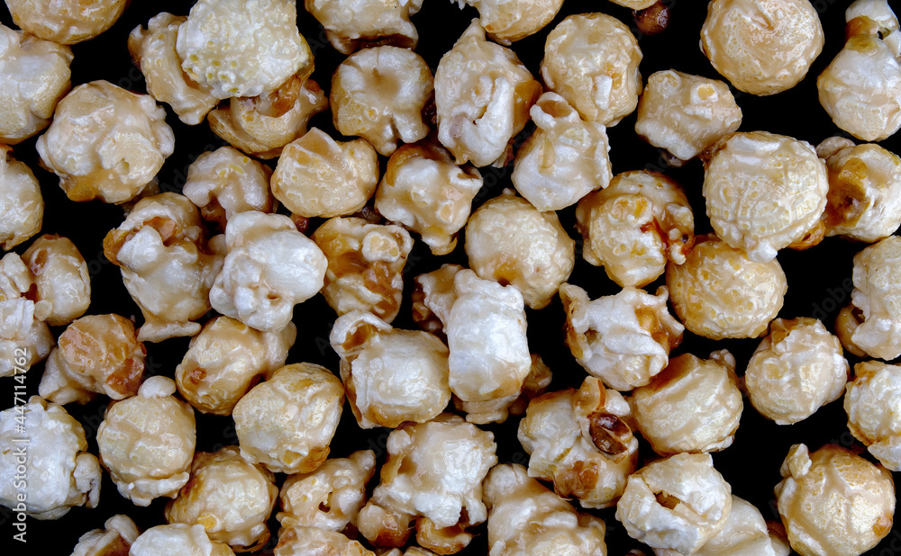 Popcorn is scattered on a black background. Popcorn background. Popcorn is scattered on a black background. Popcorn background.