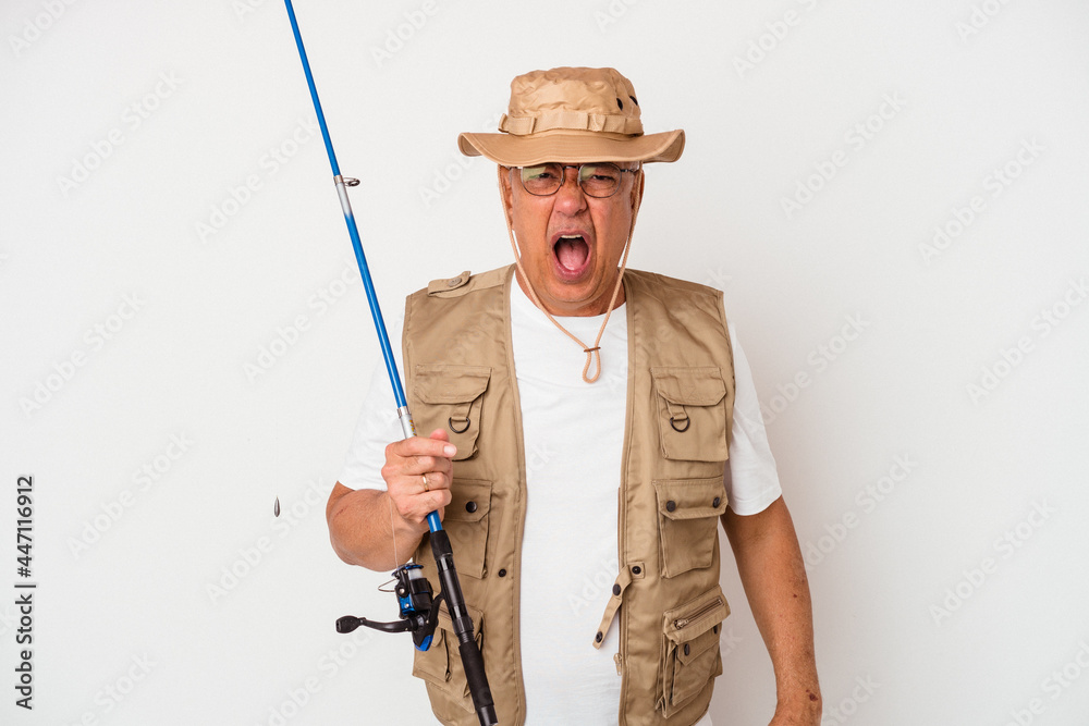 Senior american fisherman holding rod isolated on white background screaming very angry and aggressive. Senior american fisherman holding rod isolated on white background screaming very angry and aggressive.