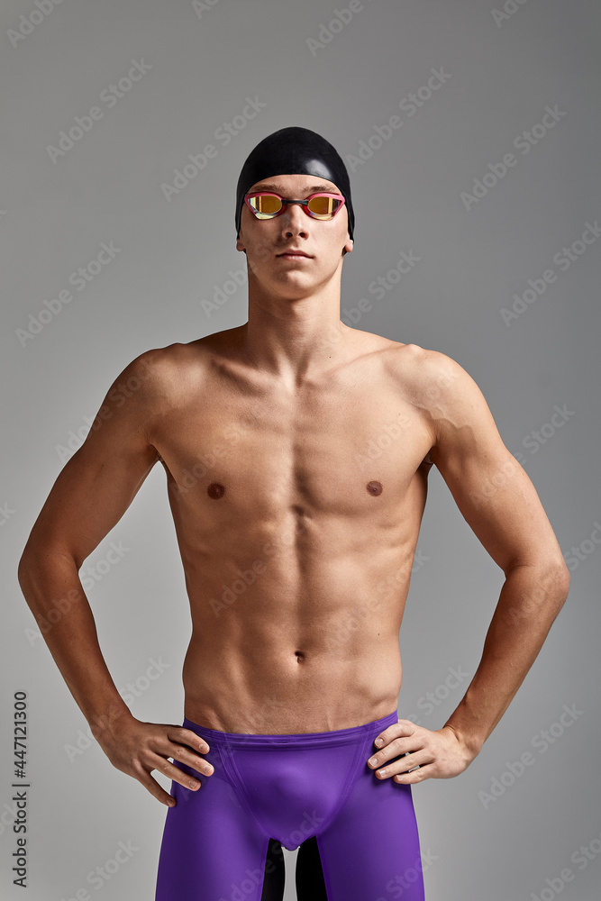 Portrait of a swimmer in a cap and mask, half-length portrait, young athlete swimmer wearing a cap and mask for swimming, copies of space, gray background Portrait of a swimmer in a cap and mask, half-length portrait, young athlete swimmer wearing a cap and mask for swimming, copies of space, gray background