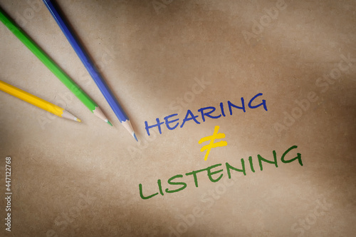 Colorful hearing not equal listening written on brown paper background with color pencil. Communication with understanding concept and soft skill idea
