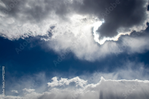 Fotografi Clouds with silver lining - dark cloud lined with white in dark blue sky with tu