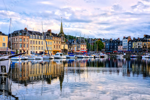 Photography Honfleur harbor with church and water reflections under late day light, Normandy