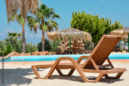 Deck chair against the backdrop of the pool  palm trees  tropical landscape.Tropical nature  beautiful landscape.Concept vacation and holiday.