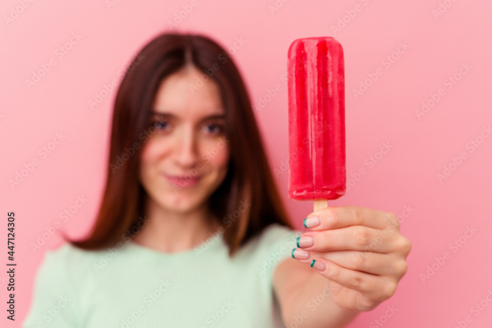 Young caucasian woman holding an ice cream isolated on pink background Young caucasian woman holding an ice cream isolated on pink background