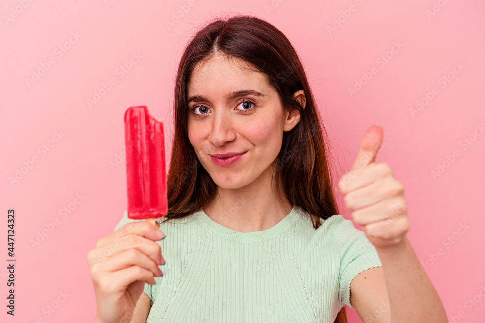 Young caucasian woman holding an ice cream isolated on pink background Young caucasian woman holding an ice cream isolated on pink background