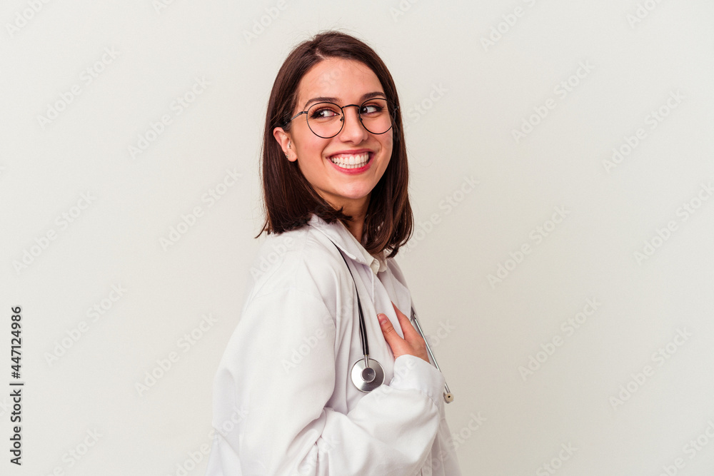 Young doctor caucasian woman isolated on white background looks aside smiling, cheerful and pleasant. Young doctor caucasian woman isolated on white background looks aside smiling, cheerful and pleasant.
