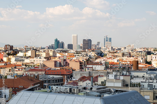 Sky line of the city of Madrid a day with many clouds with modern metal roofs and classic clay