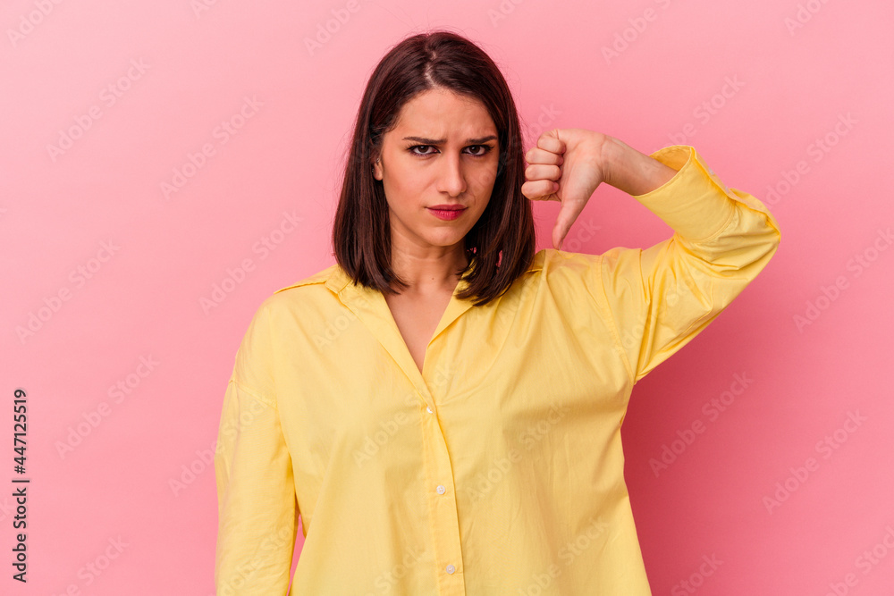 Young caucasian woman isolated on pink background showing thumb down, disappointment concept. Young caucasian woman isolated on pink background showing thumb down, disappointment concept.