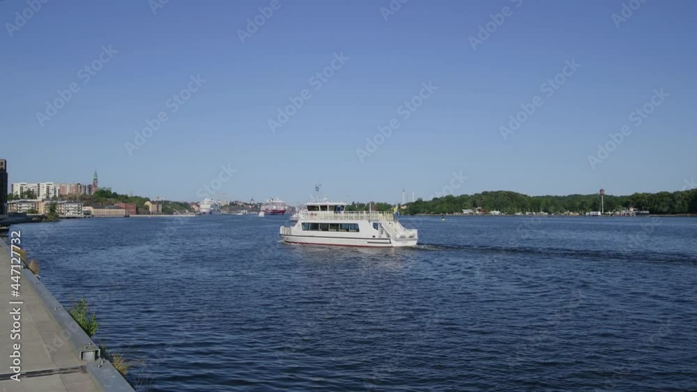 Electric powered commuting boat arrives to the pier Kvarnholmen in Stockholm with Stockholm skyline in background Electric powered commuting boat arrives to the pier Kvarnholmen in Stockholm with Stockholm skyline in background