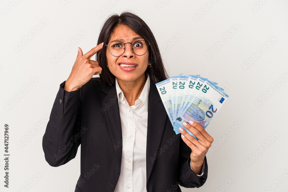 Young business latin woman holding bills isolated on white background showing a disappointment gesture with forefinger. Young business latin woman holding bills isolated on white background showing a disappointment gesture with forefinger.