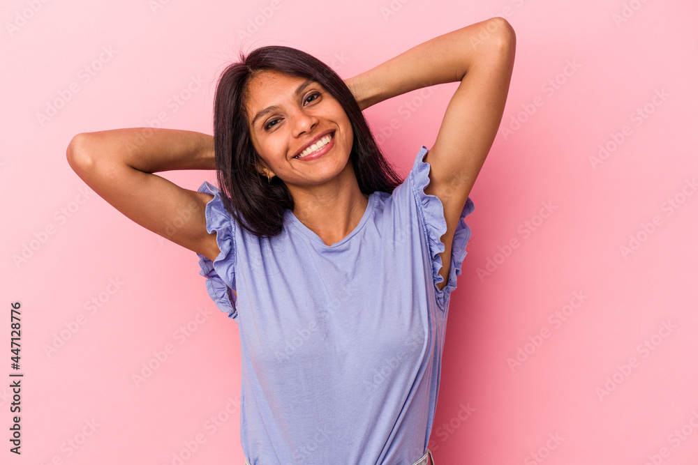 Young latin woman isolated on pink background stretching arms, relaxed position. Young latin woman isolated on pink background stretching arms, relaxed position.