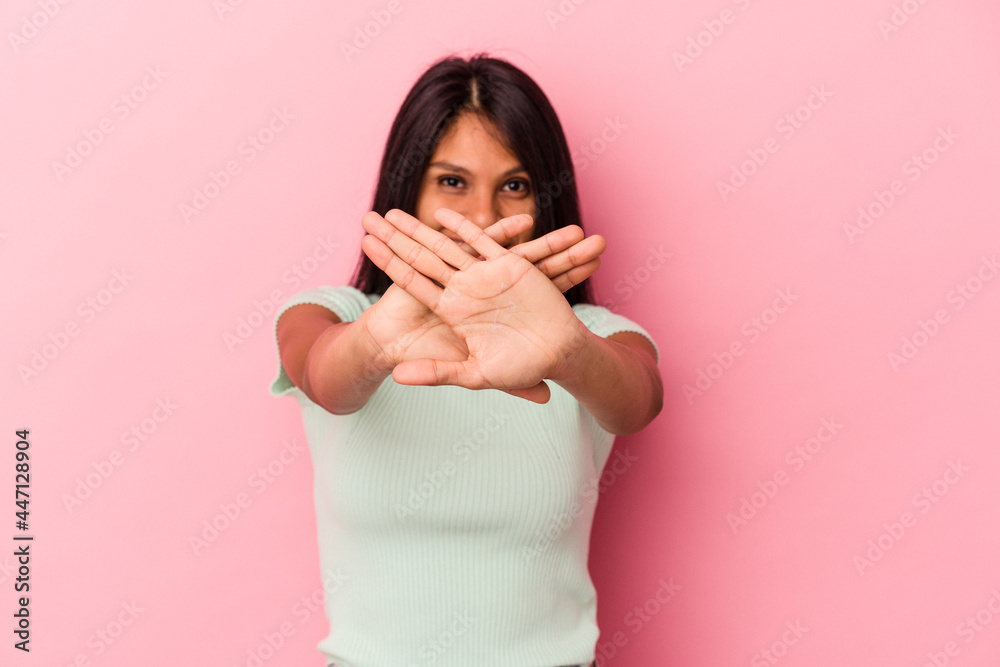 Young latin woman isolated on pink background doing a denial gesture Young latin woman isolated on pink background doing a denial gesture