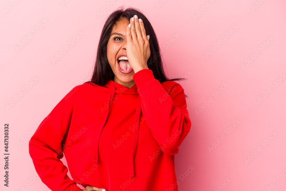Young latin woman isolated on pink background having fun covering half of face with palm. Young latin woman isolated on pink background having fun covering half of face with palm.