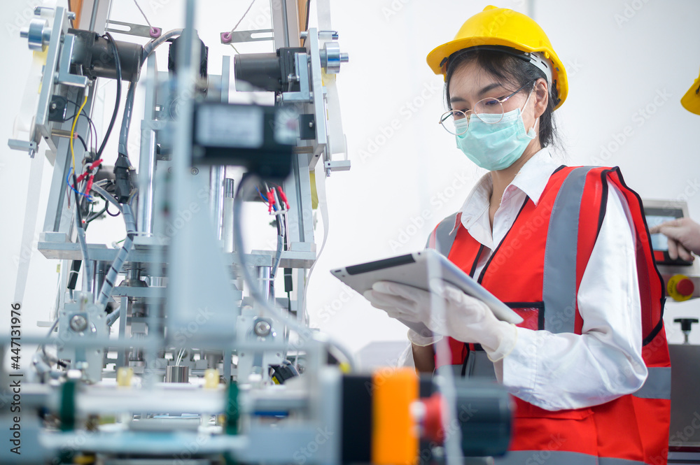 Quality control (QC) engineer monitoring and checking machine system in manufacturing factory Quality control (QC) engineer monitoring and checking machine system in manufacturing factory