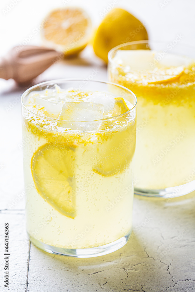 Homemade lemonade with ice in glasses, gray tiles background. Homemade lemonade with ice in glasses, gray tiles background.