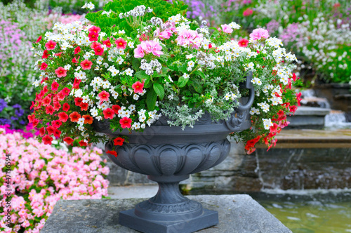 Beautiful flower arrangement in a metal pots in a summer park.