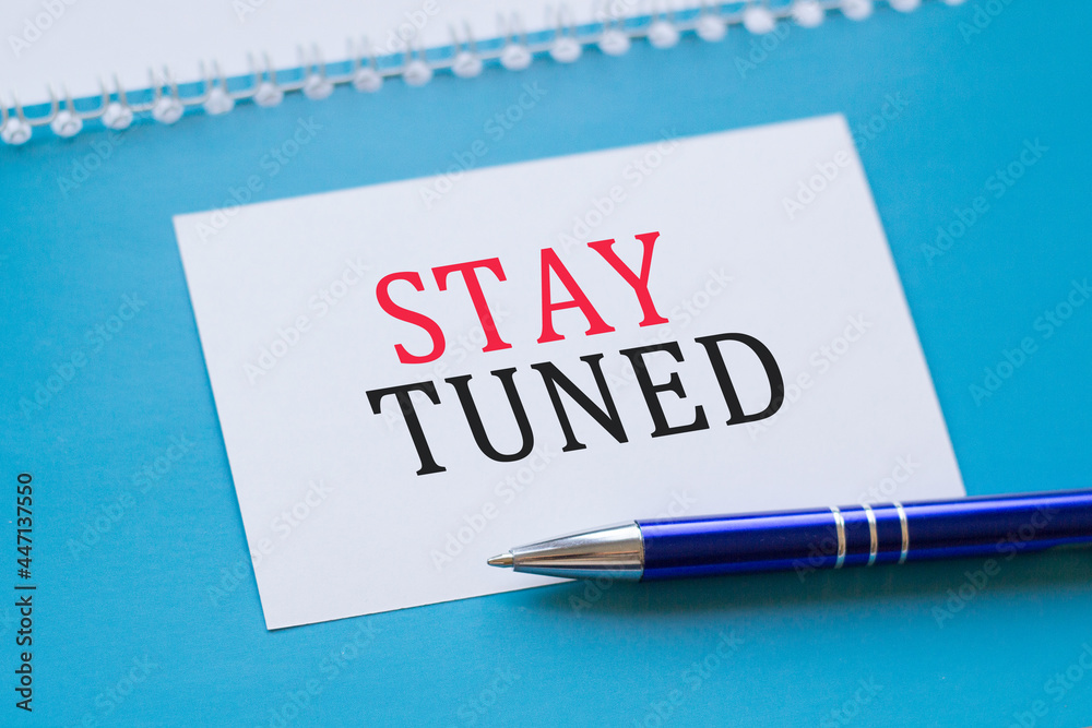 white sheet written with STAY TUNED on blu background. white sheet written with STAY TUNED on blu background.
