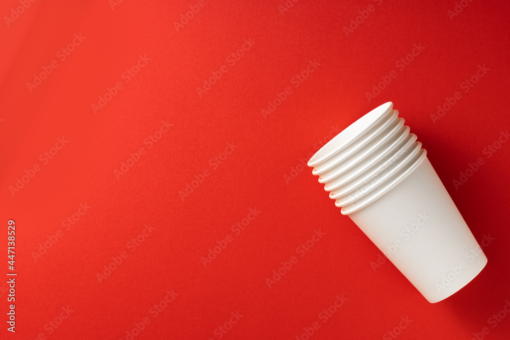 White paper cups on red background. Top view.Place for text.Ecology concept White paper cups on red background. Top view.Place for text.Ecology concept