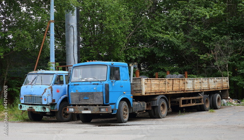 Two old rusty abandoned trucks with blue cabs, Oktyabrskaya Embankment, St. Petersburg, Russia, July 2021