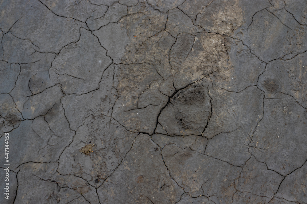 Obraz premium Close-up photo of the rough texture and gray color of the cracked earth in the area of ​​muddy volcanoes in Buzau, Romania; background photography