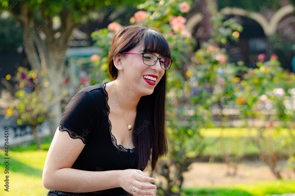 portrait of a woman with glasses smiling and laughing at the park portrait of a woman with glasses smiling and laughing at the park