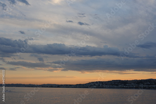 Dramatic sunset sky at dusk over Mediterranean sea at city of Nice, France, French Riviera in summer