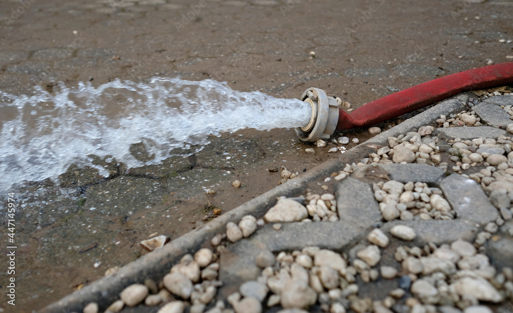 Extreme weather water being pumped out of a flooded basement in