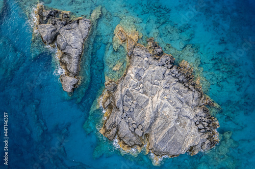 Small rocky island in still waters.