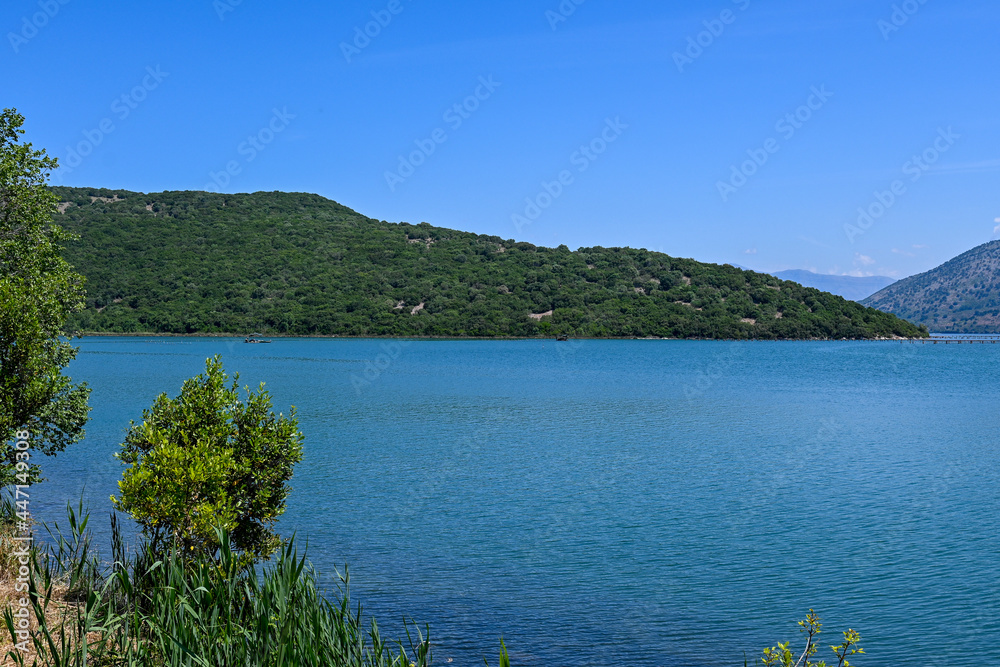 View of Lake Butrint with Butrint National Park at Lake Butrint, blue sky with water and mountains in summer in Albania