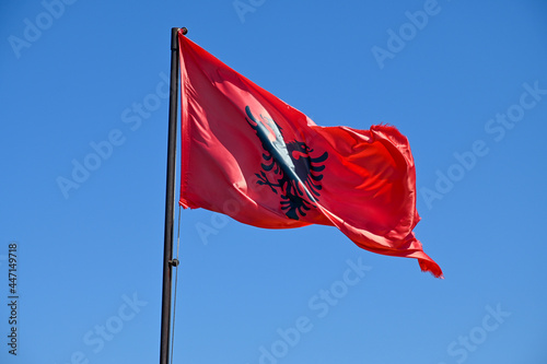 Flagge Albanien weht im Wind mit blauem Himmel photo