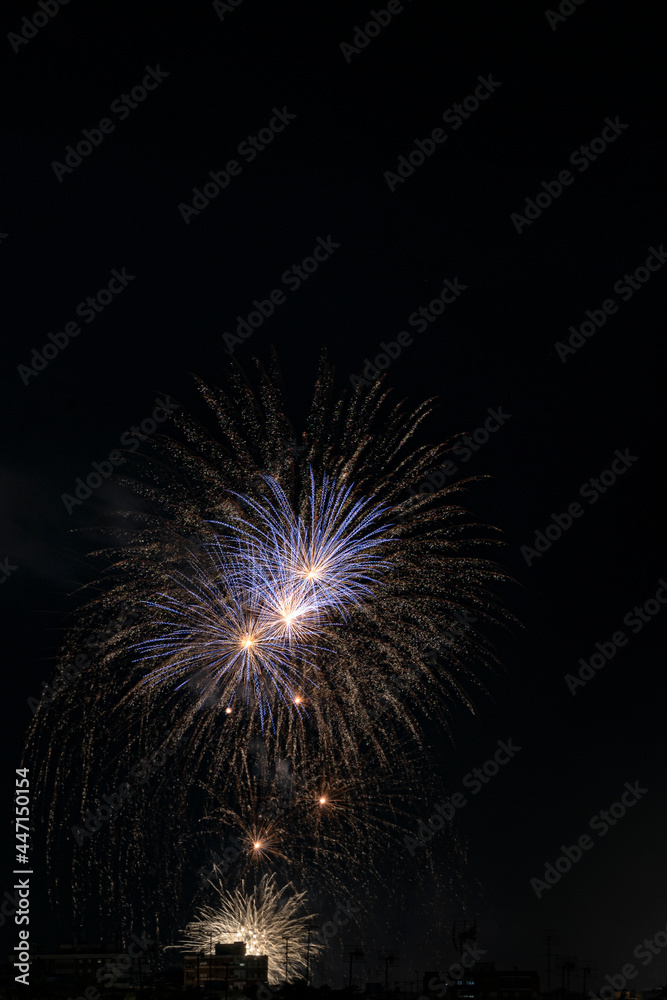 Fuegos artificiales con muchos colores sobre la ciudad y fondo negro en formato vertical con espacio. Fuegos artificiales con muchos colores sobre la ciudad y fondo negro en formato vertical con espacio.