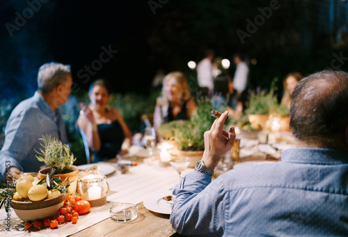 Fototapeta Guests sit at the set table and communicate with each other